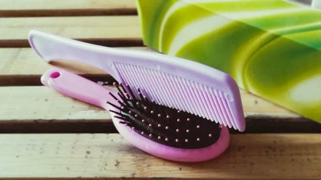 Close-up of a lice comb cleaning a hair brush.